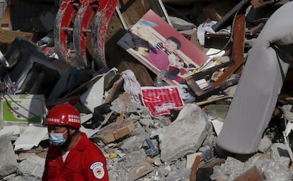 Membro de equipe de resgate trabalha entre escombros de edifício em Tainan.