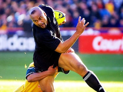 Era la gran estrella del rugby mundial hasta que una enfermedad renal lo apartó del deporte. En la fotografía, Jonah Lomu trata de escaparse de su rival durante el partido del torneo de las Tres Naciones de 2001, en el que Nueva Zelanda se enfrentó a Australia.
