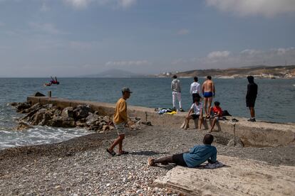Un grupo de menores, junto a su monitor, en la playa de la Almadraba, en Ceuta, este miércoles.