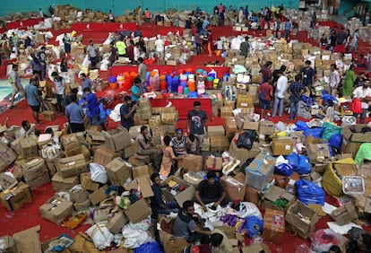 Voluntarios trabajan en la distribución de alimentos en un estadio deportivo en Kochi, Kerala, el 19 de agosto de 2018.