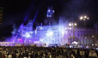 La afición del Real Madrid espera al equipo en la madrileña plaza de Cibeles.