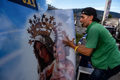 Iván Arenas decora el parabrisas de un bus con la imagen de la Virgen del Carmen, en Medellín. Desde hace más de 10 años participa en la celebración del Día de la Virgen de los Conductores, decorando vehículos en un proceso que puede tomarle hasta tres horas por bus.
