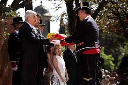 El presidente Pasqual Maragall entrega la <i>senyera</i> para que los Mossos d'Esquadra la izen, en el parque de la Ciutadella.