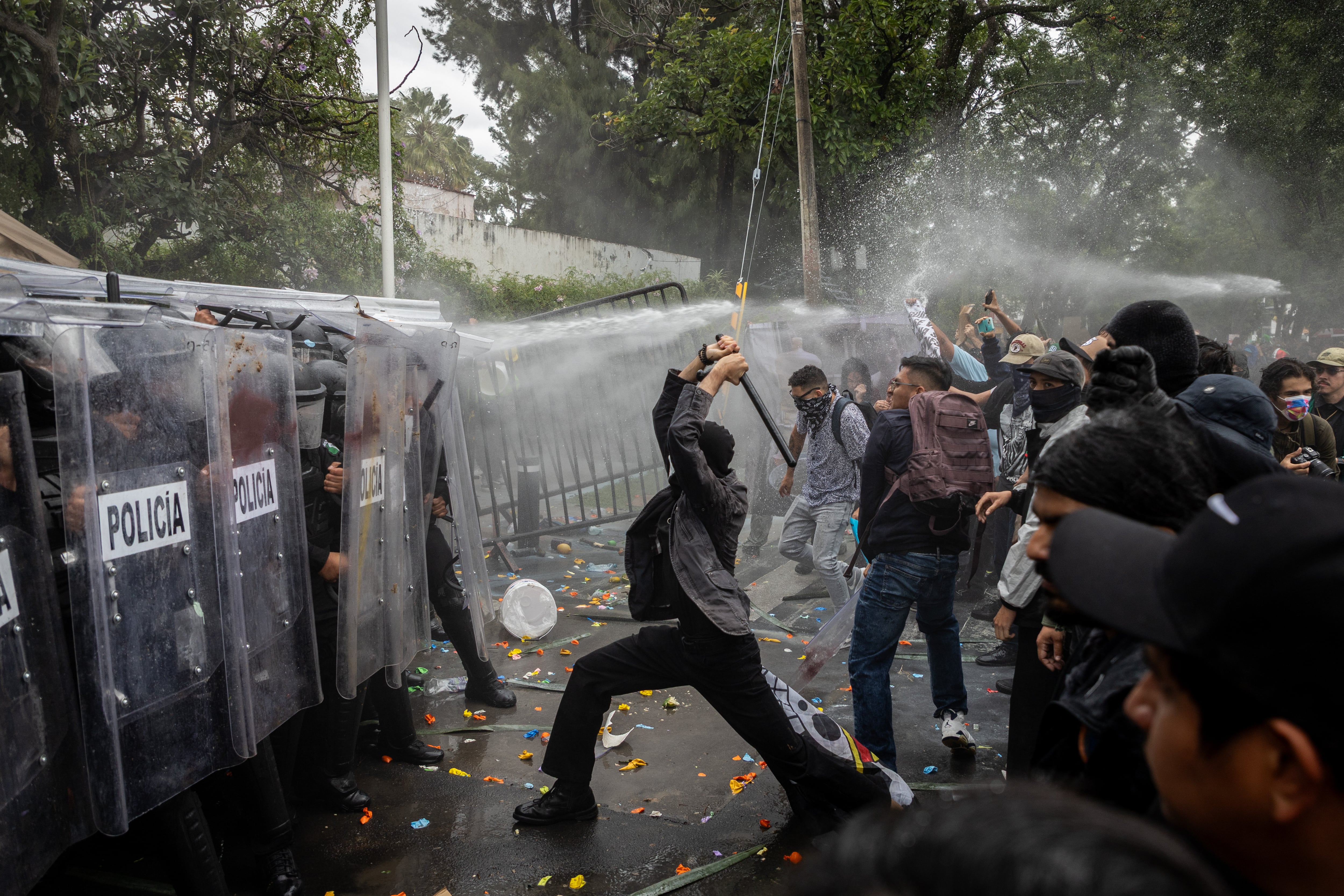 Enfrentamiento entre la policía y manifestantes al llegar a Casa Jalisco, este domingo.