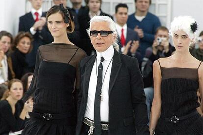 El modisto Karl Lagerfeld, alma artística de la firma Chanel, hizo patria en el segundo día de pasarela con un exquisito desfile de alta costura para la primavera-verano 2005, inspirado en el tema del "jardín a la francesa". En la imagen, el modisto cierra el desfile con dos modelos con blusas transparentes.