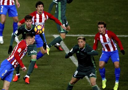 El delantero del Atlético de Madrid Fernando Torres (i) remata de cabeza ante el centrocampista francés del Real Betis Jonas Martín (2ºd).