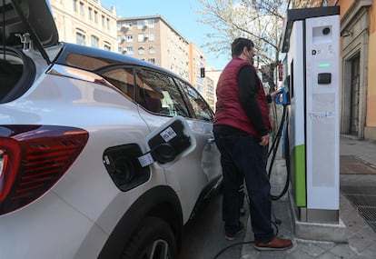 Unos usuarios intentando recargar su vehículo en un punto de recarga de coches eléctricos en Madrid.