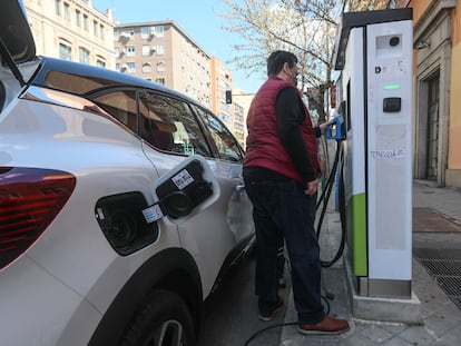 Unos usuarios intentando recargar su vehículo en un punto de recarga de coches eléctricos en Madrid.