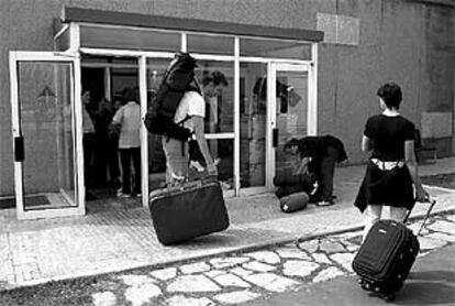 Pasajeros con destino a Barcelona recogen sus maletas perdidas en el aeropuerto de El Prat.