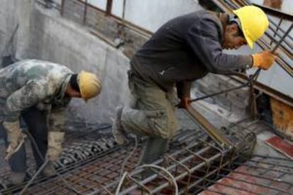 Dos operarios de la construcción trabajan en una obra en la ciudad de Shenyang, en la provincia de Liaoning (China). EFE/Archivo