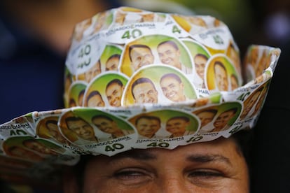 Un simpatizante de Eduardo Campos luce un sombrero con imágenes del fallecido candidato y Marina Silva, su compañera de fórmula, durante su cortejo fúnebre.