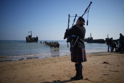 'Marines' de la Compañía 47 de la Royal Navy desembarcan en la playa de Gold Beach, en la localidad francesa de Asnelles, mientras toca un gaitero.



