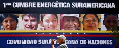 Un hombre camina frente a un cartel de la I Cumbre Energética Suramericana en la venezolana Isla de Margarita.