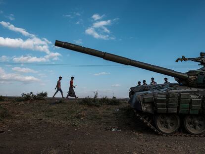 Varios jóvenes caminan junto a un tanque de los rebeldes tigrayanos abandonado cerca de Mehoni, en la región etíope de Tigray, el 11 de diciembre de 2020.