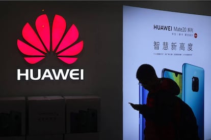 Un hombre pasa frente a una tienda de Huawei en Pekín.