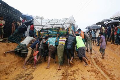 Refugiados rohingyás empujan un camión atrapado en el barro tras las fuertes lluvias en el campamento de Kutupalong, en Cox's Bazar (Bangladés).