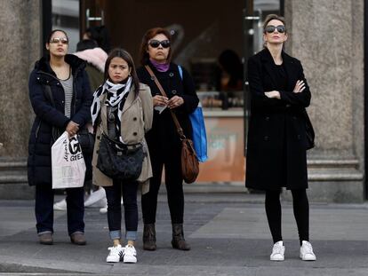 Varias mujeres esperan en un semaforo en Gran Via. 