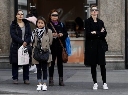 Varias mujeres esperan en un semaforo en Gran Via. 