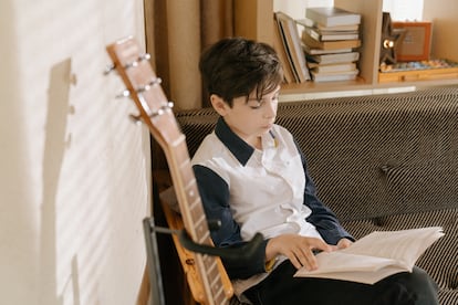 Un niño lee en su cuarto.