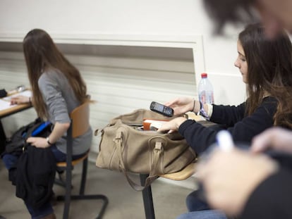 Garota francesa consulta seu celular na sala de aula.