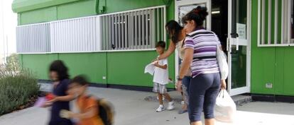 Ni&ntilde;os y madres a la salida de los barracones del colegio de Batres.