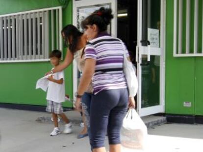 Ni&ntilde;os y madres a la salida de los barracones del colegio de Batres.