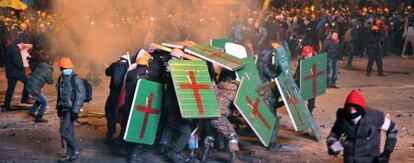 Un grupo de manifestantes se protege con escudos.