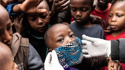 Un grupo de niños se agolpa para el reparto de comida en Nairobi (Kenia).