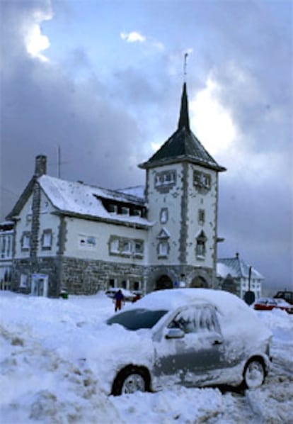 El temporal de nieve mantiene aislados medio centenar de pueblos del suroccidente de Asturias, donde permanecen cerrados al tráfico ocho puertos y son necesarias las cadenas para circular por otros once pasos de montaña. En la imagen, aspecto que presentaba esta tarde el pueblo de Pajares.