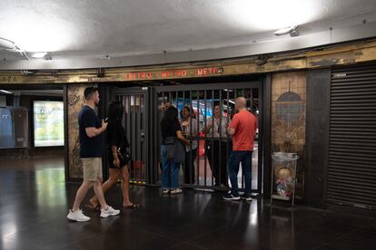 Las empleadas del metro de Barcelona cierran el acceso a la línea 3 por un desprendimiento del túnel, este martes.