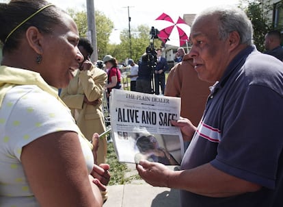 Un hombre muestra la primera página del periódico 'The Plain Dealer' cerca de la Avenida Seymour, próxima a la casa donde fueron encontrados con vida las tres chicas secuestradas hace diez años.