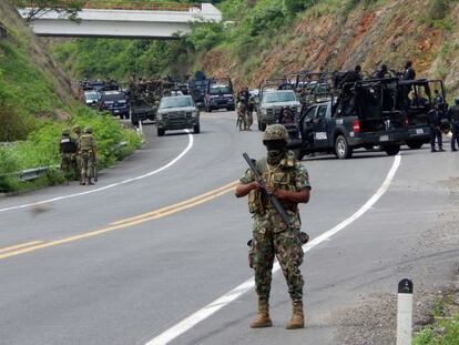 Soliders stand guard on a highway near the town of Arteaga, Michoacán state, where 22 killings were reported Tuesday.