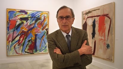 El pintor abstracto Manuel Salinas posa ante dos de sus pinturas en la exposición sobre su obra en la sala Chicarreros de Sevilla, en 2003.