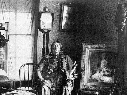 Quanah en su dormitorio, hacia 1897. A su izquierda, el retrato enmarcado de su madre, Cynthia Ann, y su hermana, Flor de la Pradera.