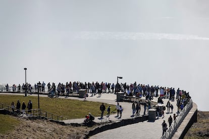 Larga fila de turistas esperan para observar el eclipse total de sol, sobre las Cataratas del Niágara. 