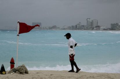 Un socorrista, junto a una bandera roja en Cancún.