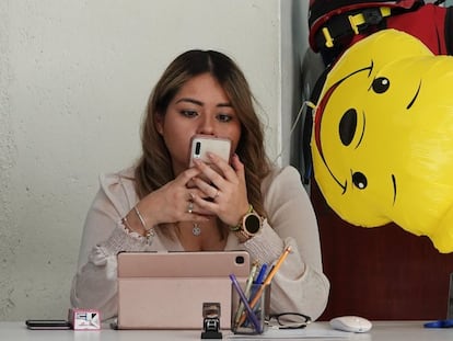 Una mujer revisa su teléfono celular en una oficina en Ciudad de México.