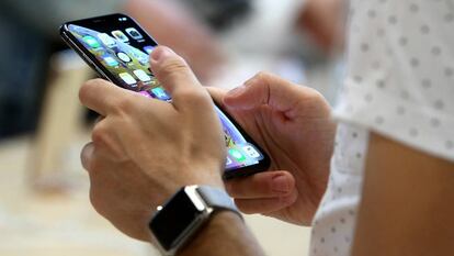 Un usuario sostiene un iphone en la tienda de Apple de la Puerta del Sol de Madrid.