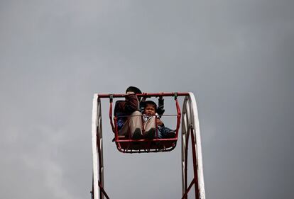 Unos niños montados en una noria durante la celebración del año nuevo afgano en Kabul, Afganistán.