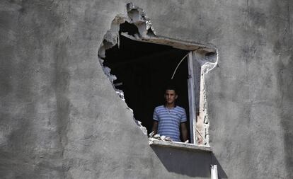 Un residente de la ciudad turca de Akcakale, en la frontera con Siria, mira a través de un muro dañado por un mortero, el pasado 12 de octubre.