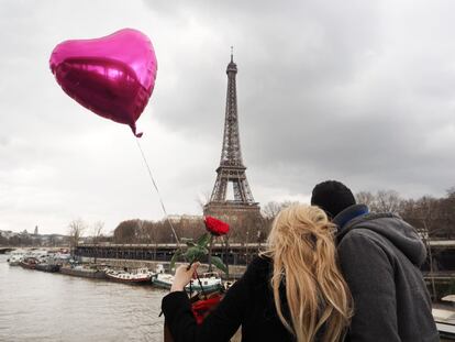 Una pareja celebra el día de San Valentín en frente de la Torre Eiffel.