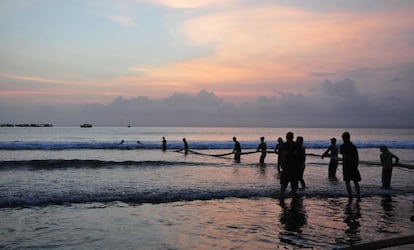 Un grupo de pescadores recoge sus redes al atardecer en la playa de Pangandaran (Indonesia).