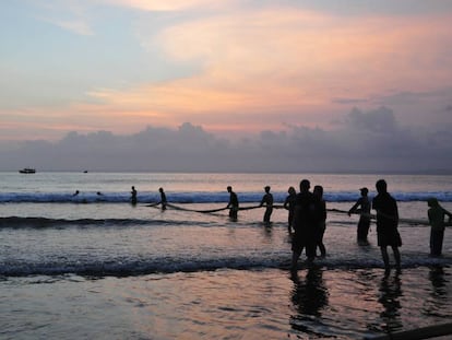 Un grupo de pescadores recoge sus redes al atardecer en la playa de Pangandaran (Indonesia).