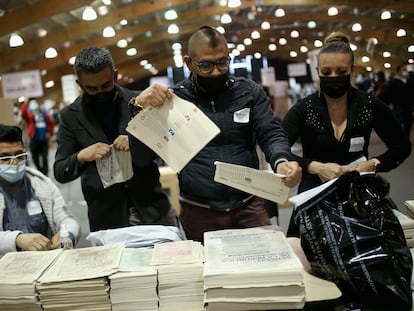 Jurados electorales rompen las papeletas sin marcar después de las elecciones legislativas en Colombia, el 13 de marzo de este año.