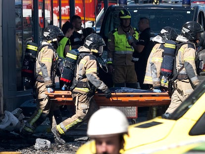 Varios bomberos trasladan uno de los once cuerpos rescatados durante este domingo de las discotecas incendiadas en Murcia.