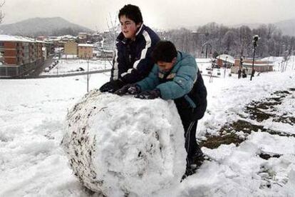 Dos niños jugando con una gran bola de nieve, ayer en Olot (Garrotxa).