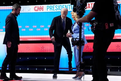 El presidente de Estados Unidos, Joe Biden, baja de la tarima donde se acababa de celebrar el debate presidencial con la ayuda de la primera dama, Jill Biden. 