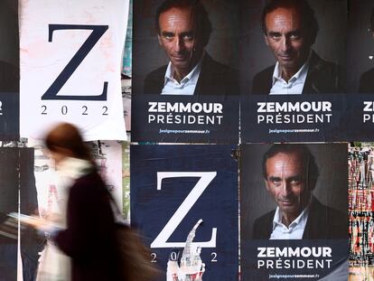 Una mujer pasa frente a los carteles electorales de Éric Zemmour, candidato de ultraderecha a las elecciones francesas.