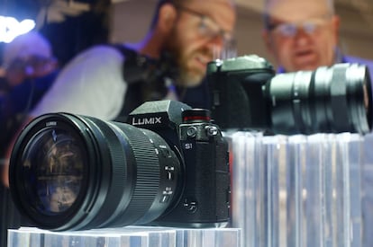 Dos visitantes miran la nueva cámara full frame sin espejo de Panasonic, el 26 de septiembre de 2018, en Colonia.  