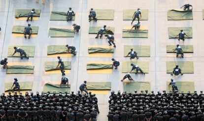 Estudiantes universitarios participan en una competición de doblar edredones durante un entrenamiento militar.